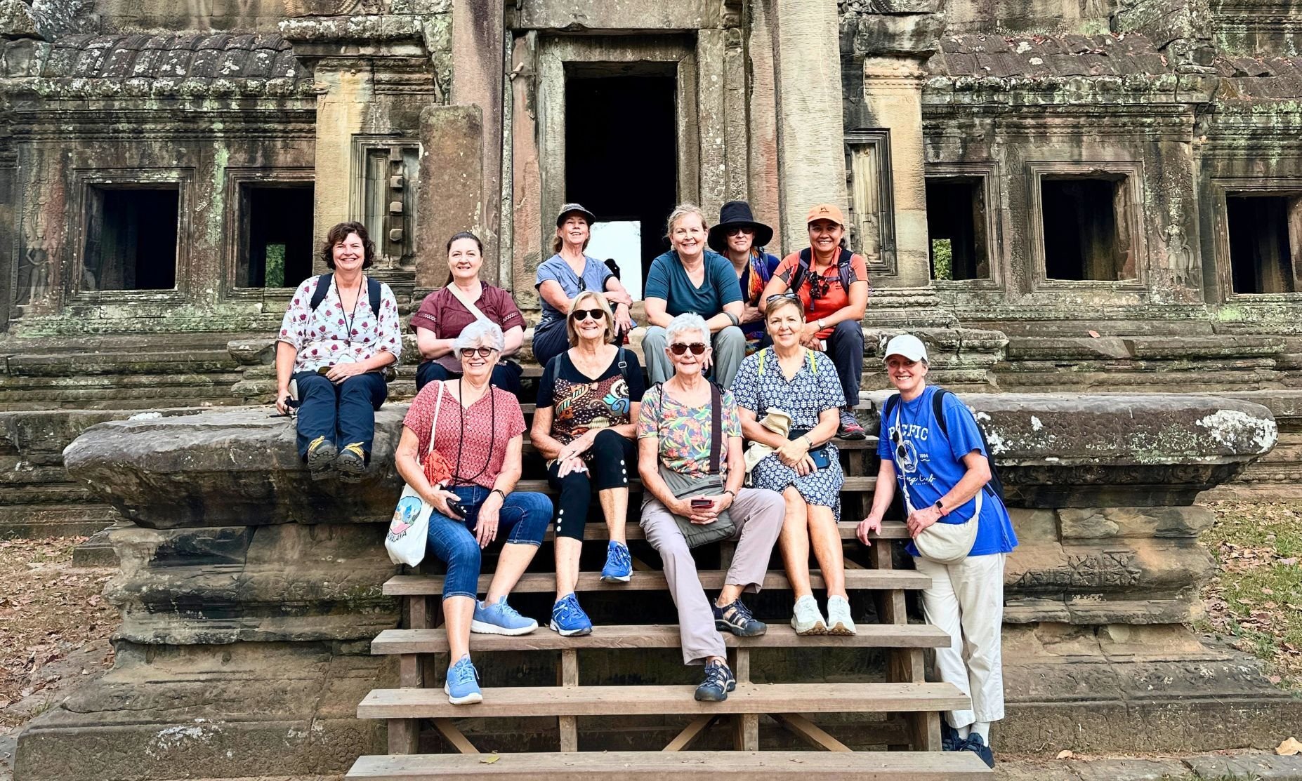 Group of women on steps of ancient ruins of Angkor Wat