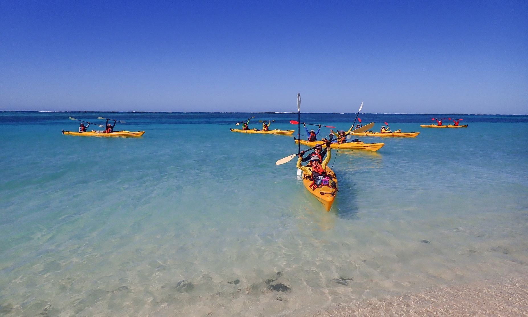 Happy kayakers on crystal clear water