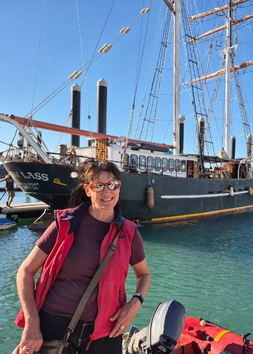 Traveller in front of tall ship
