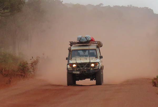 landcruiser driving along dusty road with lights on