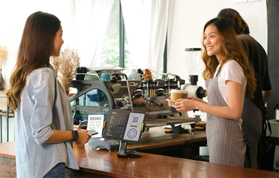barista serving takeaway coffee to girl
